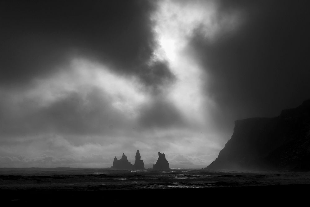 Dark sky over rock formations in a stormy sea. Original public domain image from Wikimedia Commons