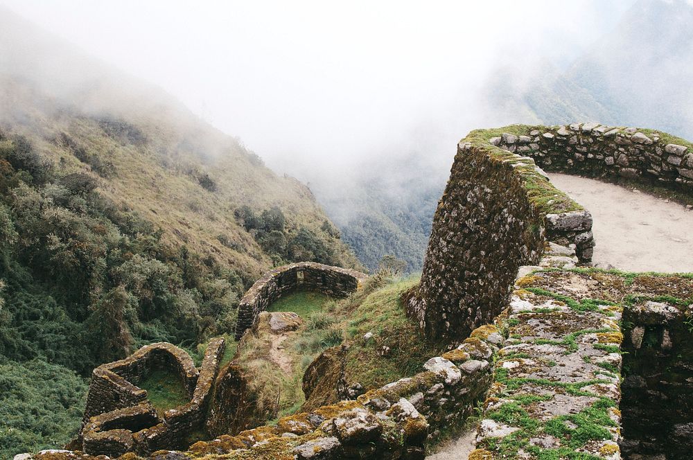 Rocky Inca ruins covered in moss on a misty mountain. Original public domain image from Wikimedia Commons