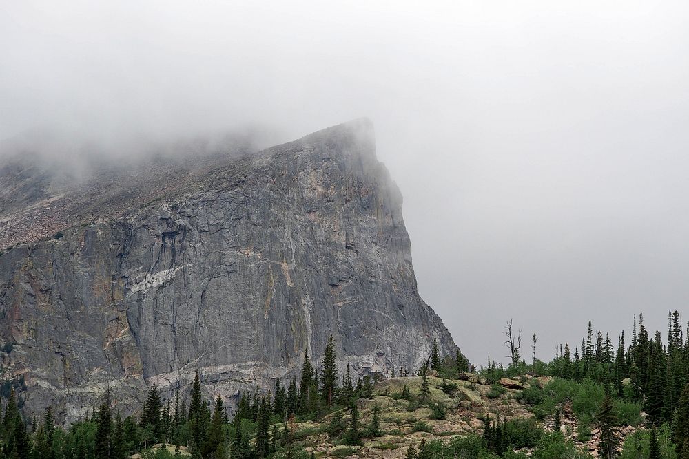 A steep rock face wreathed in fog. Original public domain image from Wikimedia Commons