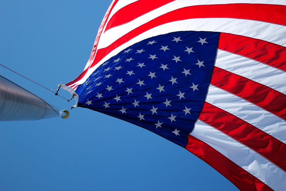 USA flag waving under blue sky. Original public domain image from Wikimedia Commons