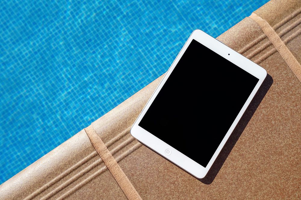 An iPad on the edge of a swimming pool. Original public domain image from Wikimedia Commons