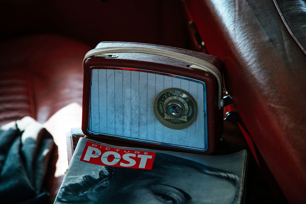 Radio and magazine on the seat of the vintage car.. Original public domain image from Wikimedia Commons