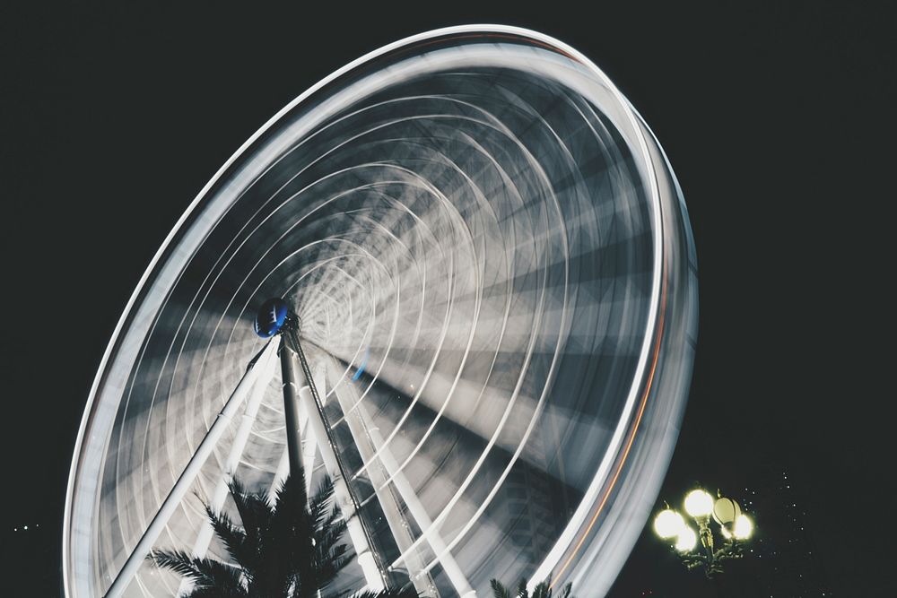 An illuminated Ferris wheel in Al Qasba in motion with timelapsed light trails. Original public domain image from Wikimedia…