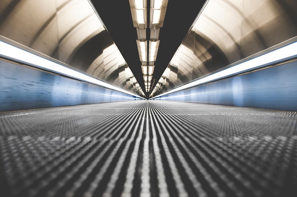 A low shot of a long moving sidewalk in a tunnel in Paris. Original public domain image from Wikimedia Commons