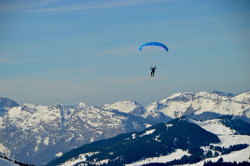 Person parachutes over mountains in a blue landscape. Original public domain image from Wikimedia Commons