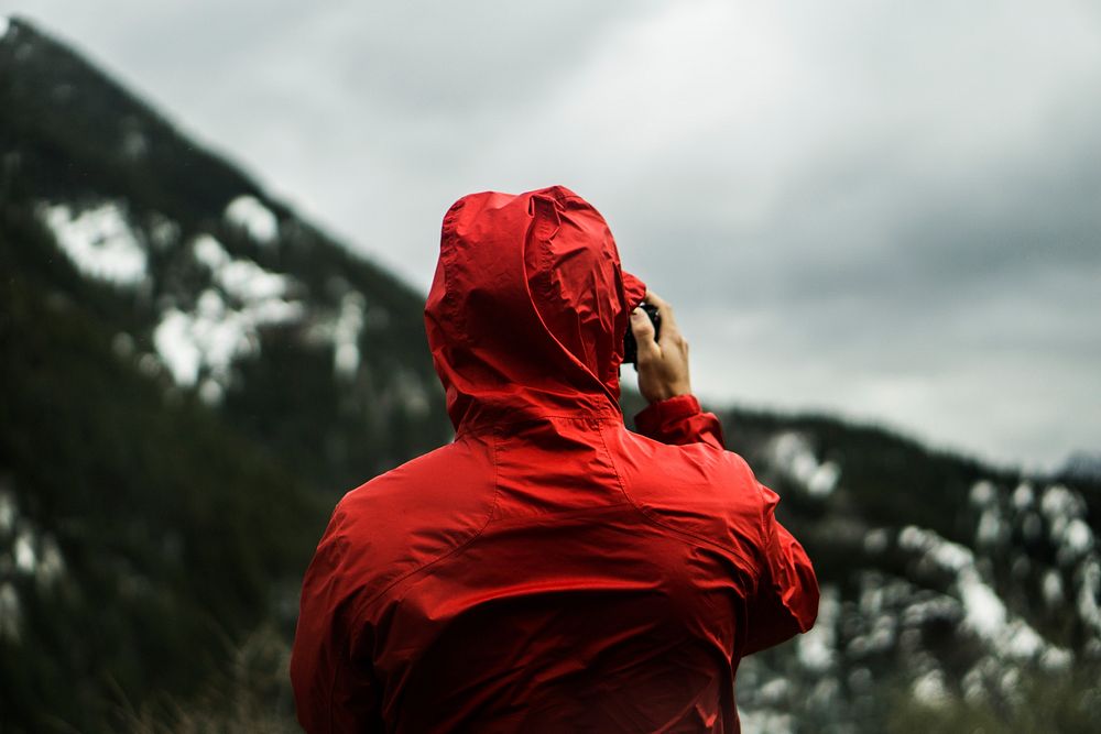 Person in a red jacket surveys a mountain landscape. Original public domain image from Wikimedia Commons