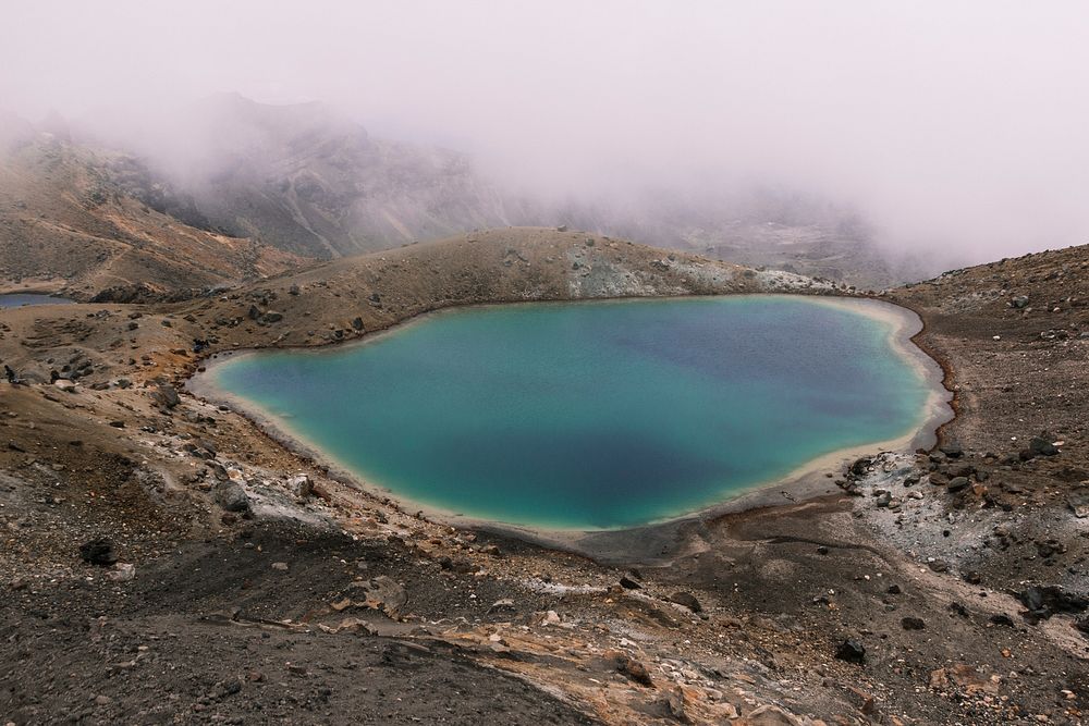 Blue lagoon surrounded by barren mountains on a misty morning. Original public domain image from Wikimedia Commons