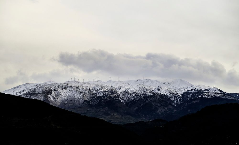 A wind farm on snow-topped mountains in Drepano. Original public domain image from Wikimedia Commons