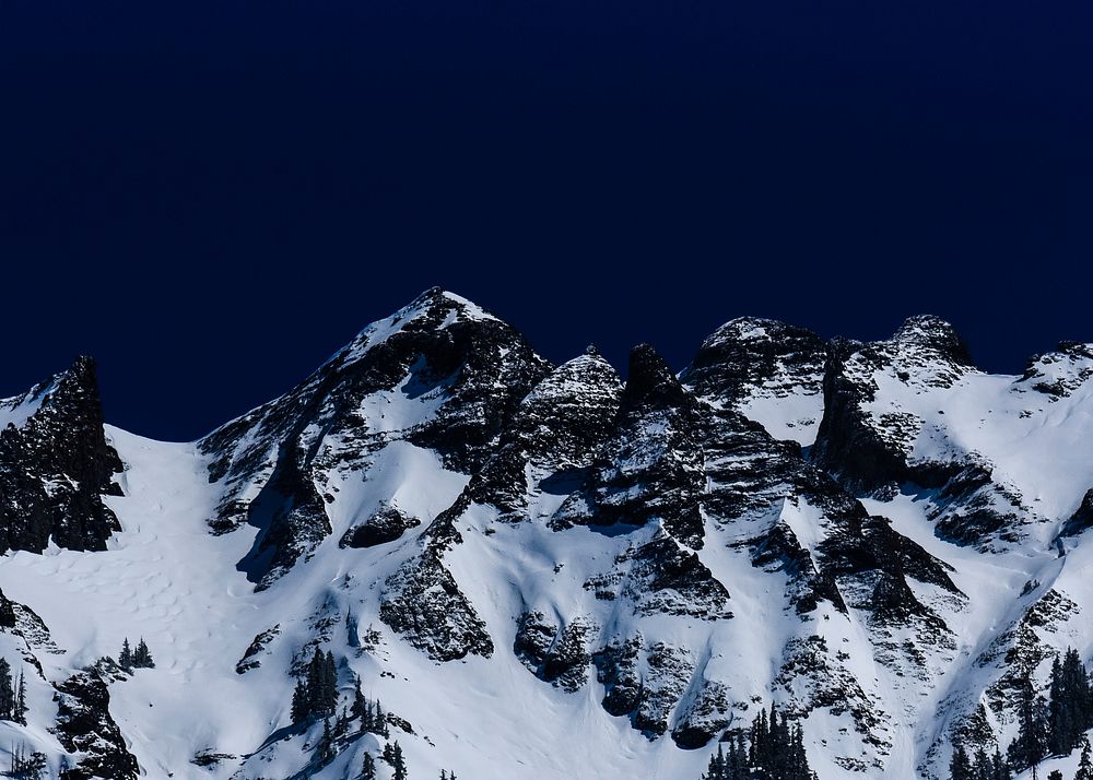 A snowy mountain's crest against a dark sky in Ouray. Original public domain image from Wikimedia Commons