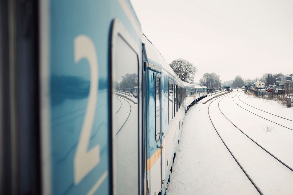 The railway tracks covered in snow as seen from the side of the train. Original public domain image from Wikimedia Commons