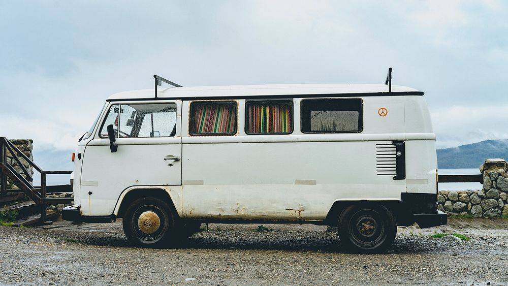 A white van parked on a gravel surface by a lake. Original public domain image from Wikimedia Commons