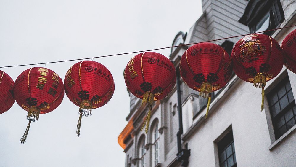 Row of red Chinese lanterns hanging above a street.. Original public domain image from Wikimedia Commons
