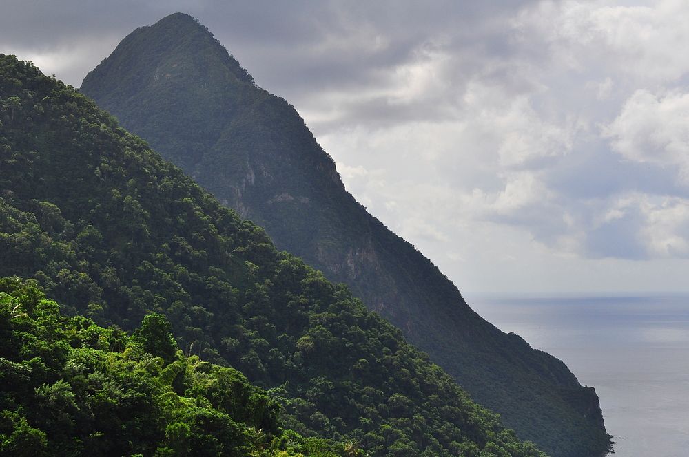 A tall wooded mountain peak at the seashore. Original public domain image from Wikimedia Commons