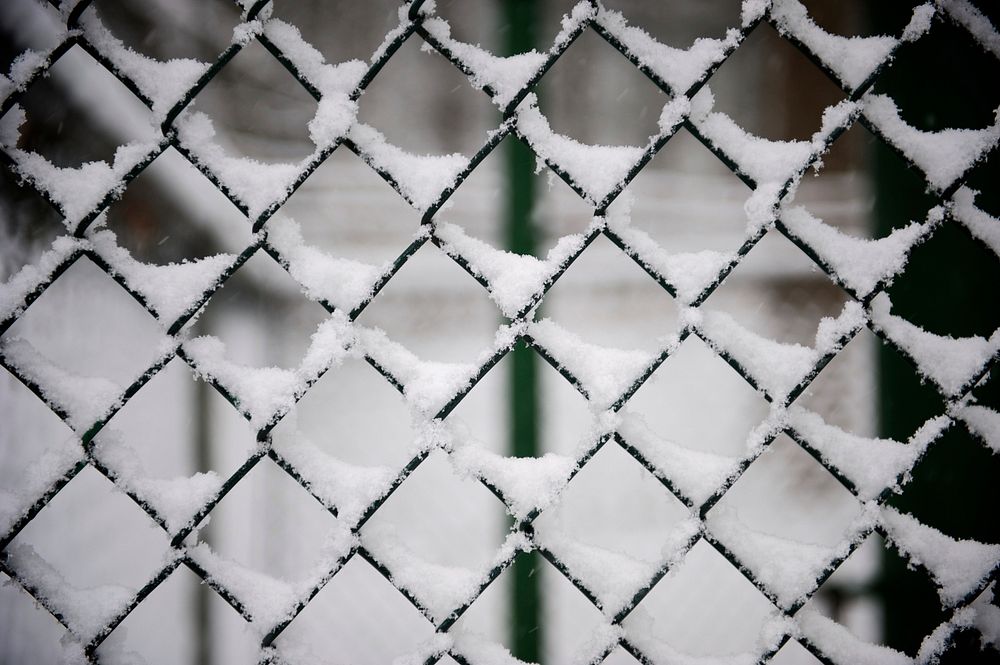 A macro view of a chainlink fence covered with snow in winter.. Original public domain image from Wikimedia Commons