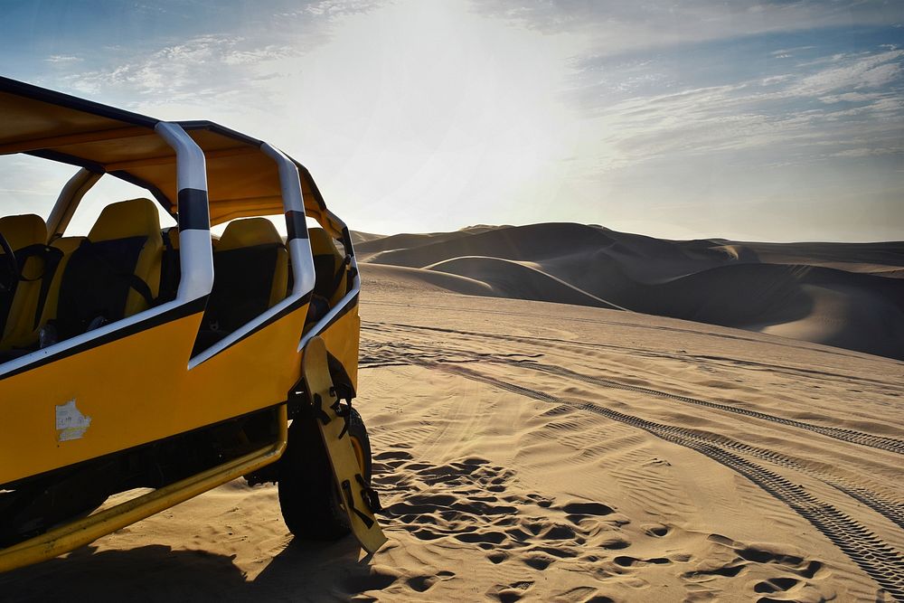 Car parked in the sand dunes of the Ksar Ghilane desert. Original public domain image from Wikimedia Commons