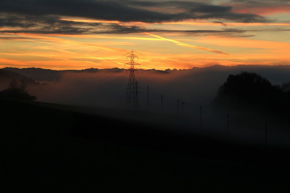 Pylons in the distance of a cloudy sunset scene in Bern. Original public domain image from Wikimedia Commons