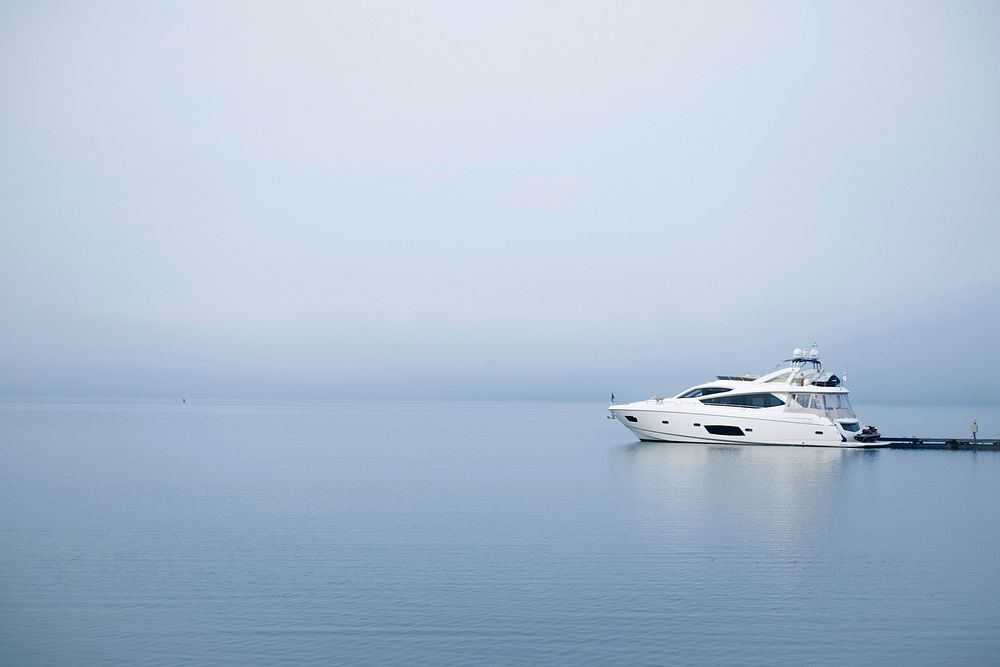 Yacht rides across calm ocean on a foggy day. Original public domain image from Wikimedia Commons