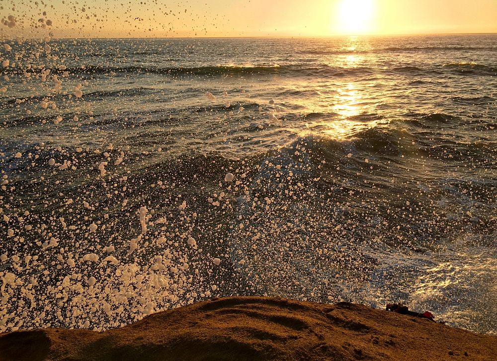 Water splashing into Sunset Cliffs coastline as the sun sets. Original public domain image from Wikimedia Commons