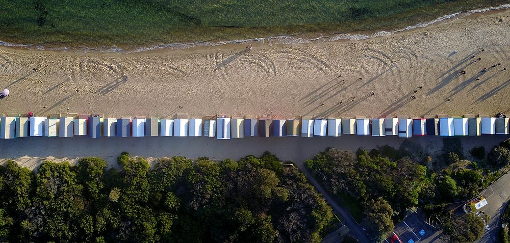 Drone aerial view of beach huts in line at the Brighton sand Beach Boxes. Original public domain image from Wikimedia Commons
