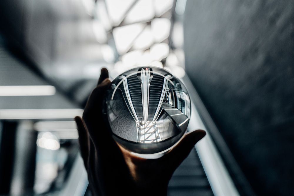 The reflection of the ceiling and stairs in a glass ball in Canary Wharf.. Original public domain image from Wikimedia…