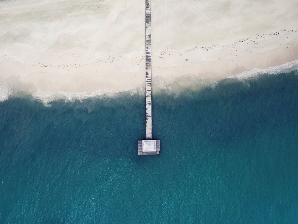 Drone aerial view of a long wooden pier at the sand beach in Hon'daafushi. Original public domain image from Wikimedia…