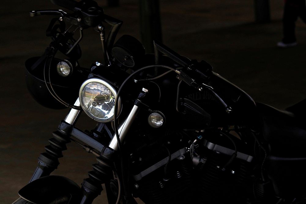 Black motorbike parked in a dark lot. Original public domain image from Wikimedia Commons