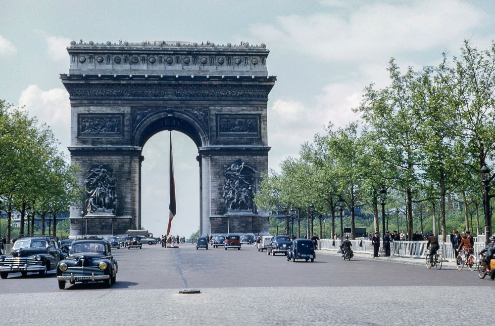 Old photography of the Arc de Triomphe in Paris with old vintage cars and cyclists on the road.. Original public domain image…