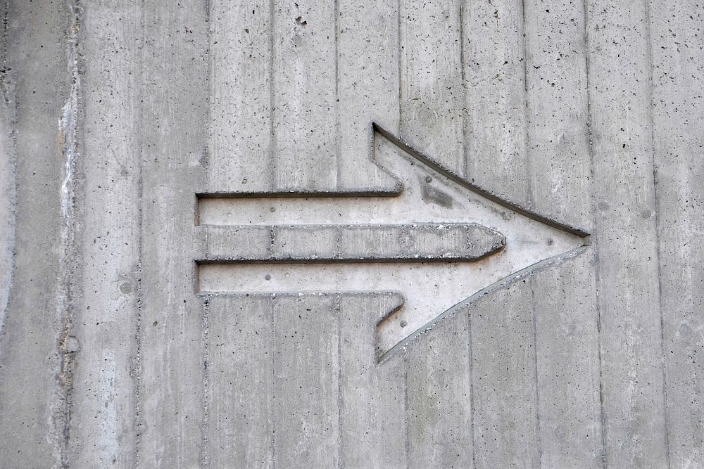 An arrow etched in a concrete wall. Original public domain image from Wikimedia Commons