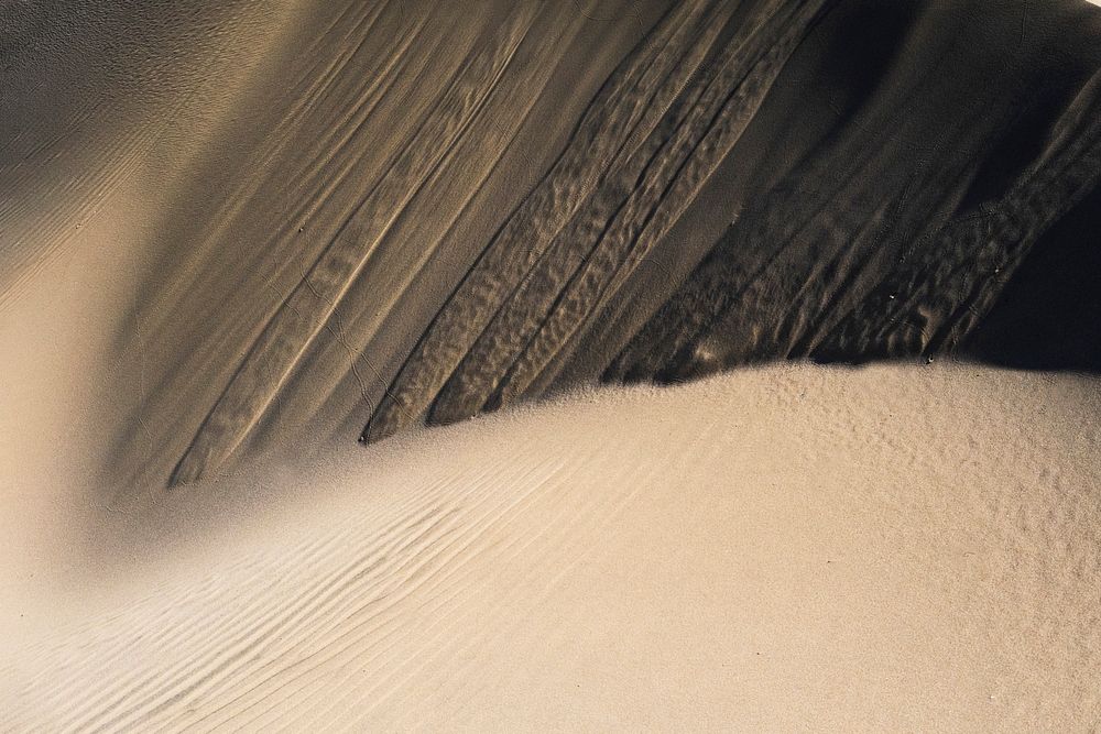 Macro shot of wavy texture and wind patterns in the sand. Original public domain image from Wikimedia Commons
