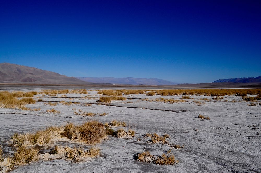 Desolate desert terrain and blue sky in Death Valley. Original public domain image from Wikimedia Commons