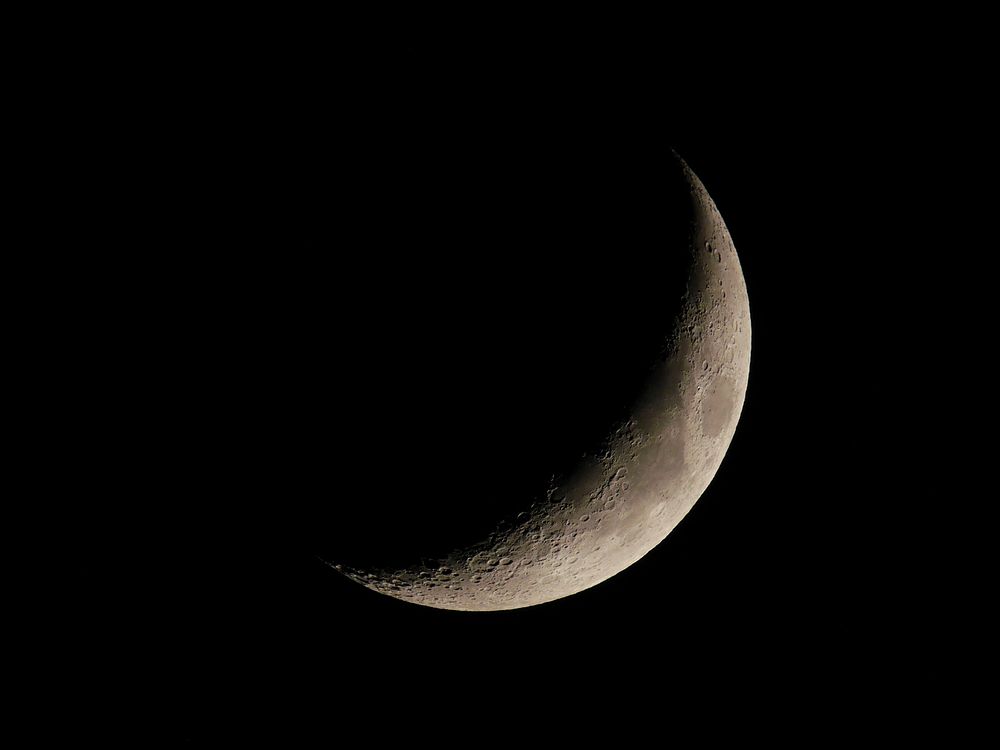 A waning crescent moon close up in a dark night sky.Original public domain image from Wikimedia Commons