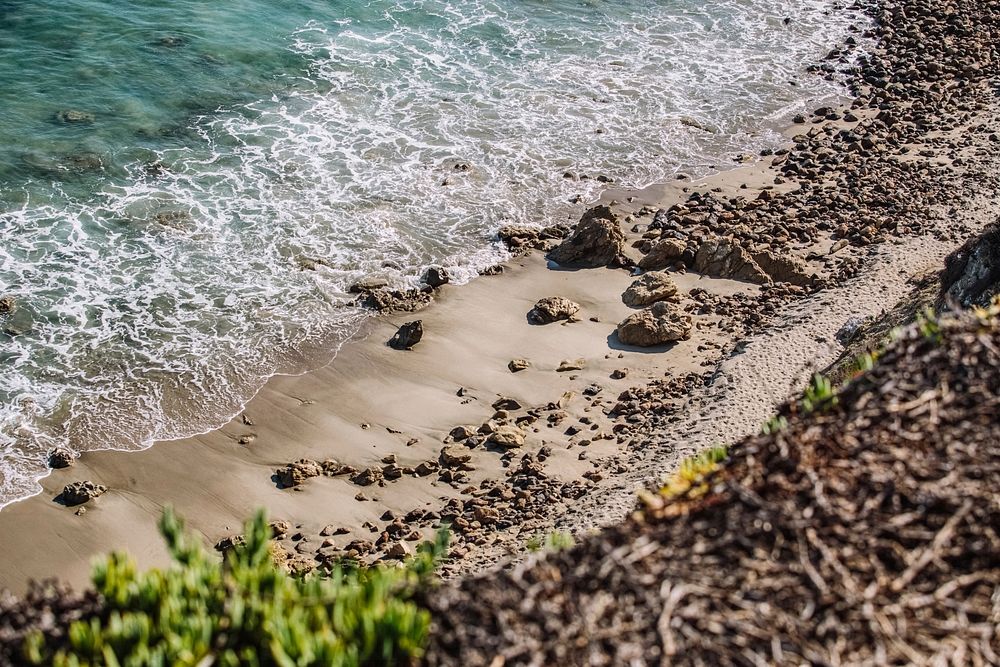 Ocean washing on the sandy and rocky coastline viewed from the hill above at Point Dume State Beach. Original public domain…