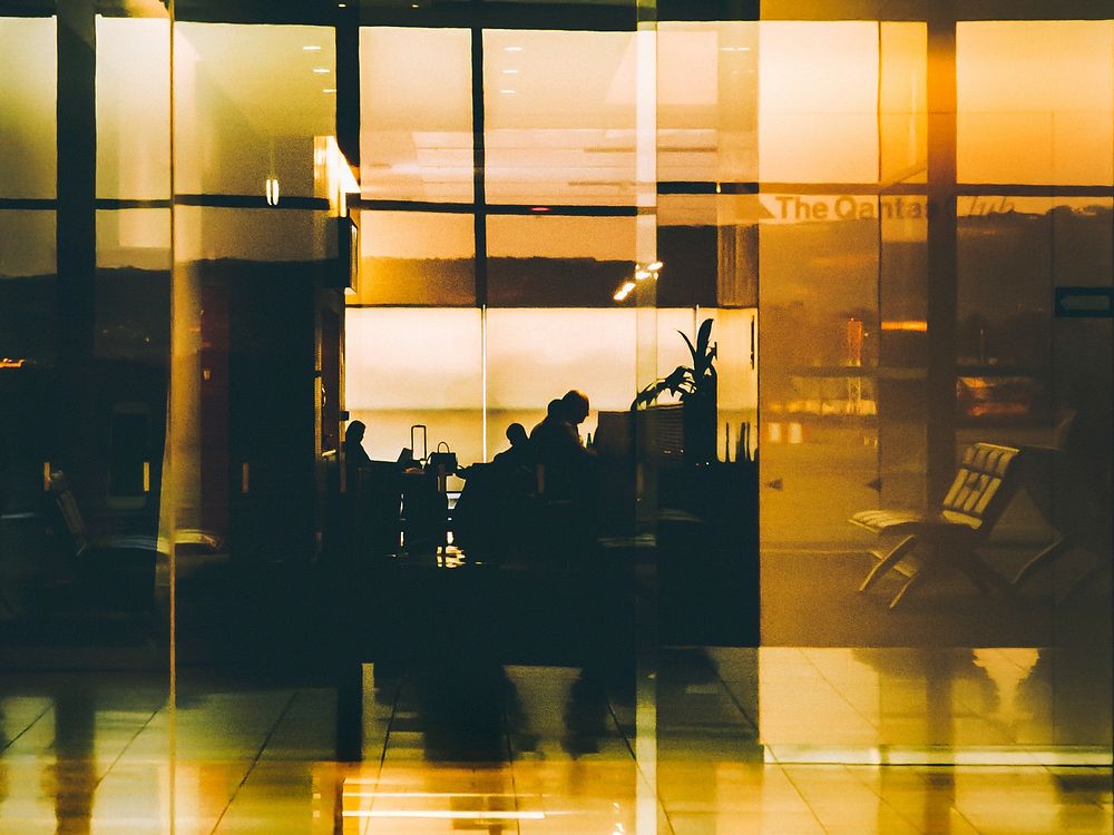 A fuzzy shot of silhouettes of people reflected in a glossy wall at the Adelaide Airport. Original public domain image from…