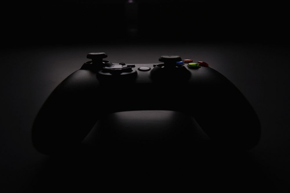 A dark background photograph of an Xbox controller. Original public domain image from Wikimedia Commons