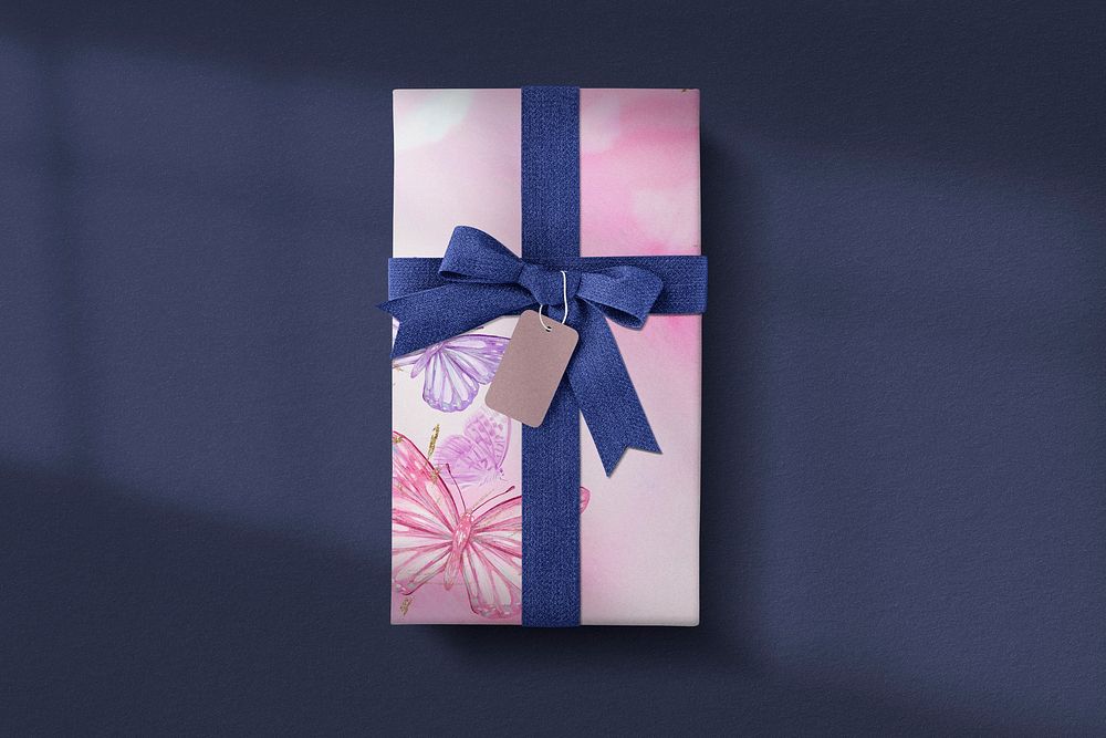 Pink gift box with blue ribbon on dark background