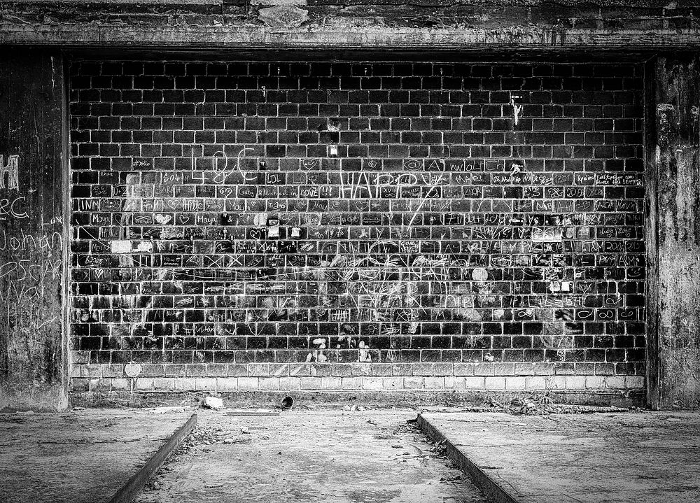 Free old brick wall with writing in black and white image, public domain CC0 photo.