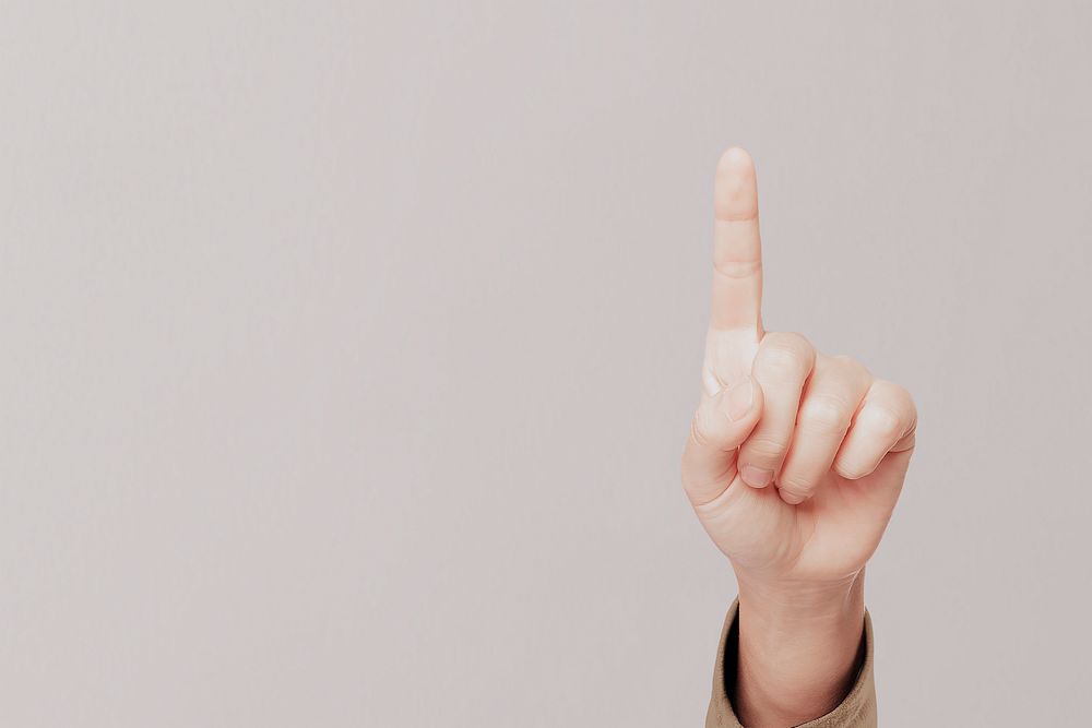 Female hand pointing, beige background psd
