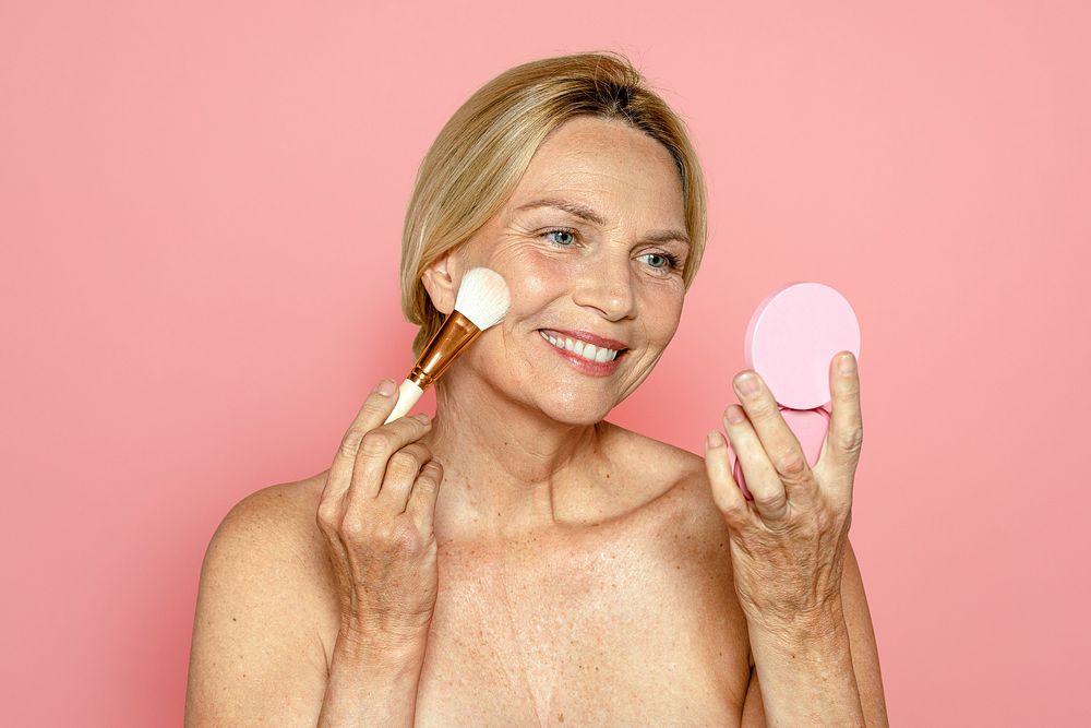 Mature woman applying blush, makeup & cosmetics psd