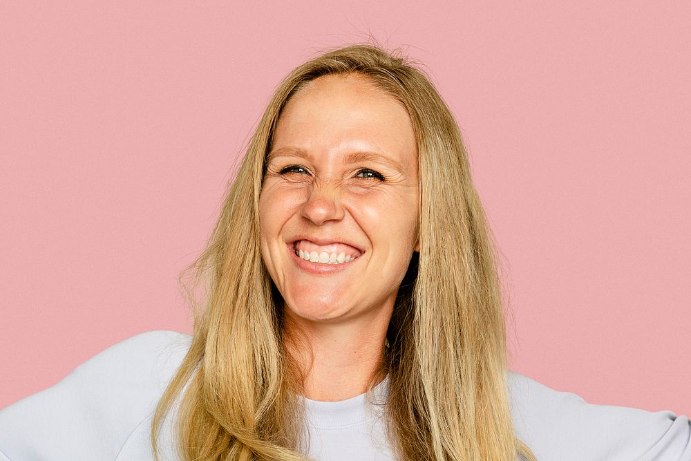 Blonde woman smiling on pink background