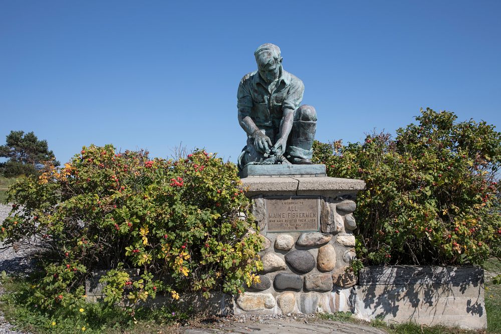 Memorial to lost fishermen at land's end on Bailey Island, Maine.  At first glance it appears the figure is tending to…