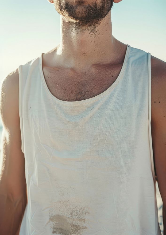 Man wearing white tank top shoulder clothing sweating.