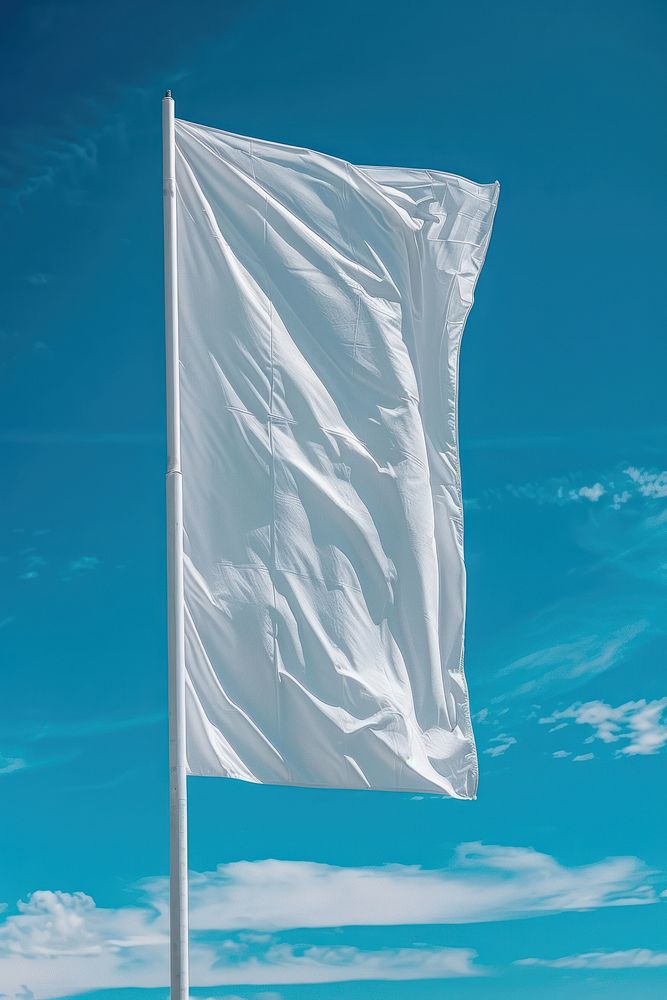 Empty white vertical flag against blue sky without clouds.