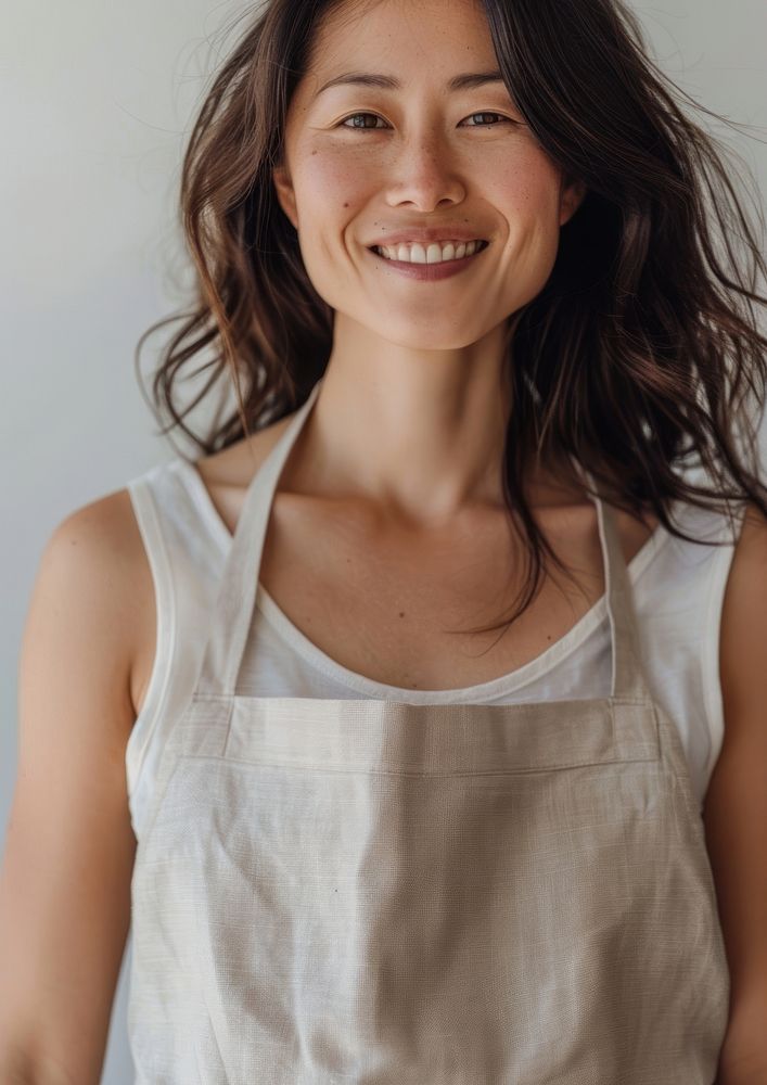 Asian women wearing light bronw linen fabric apron happy face dimples.