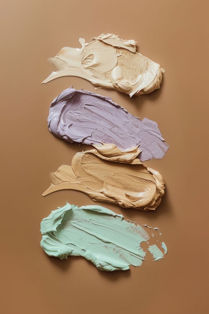 Liquid face foundation swatch in 4 shades of beige brown pale green and purple colors dessert cream creme.