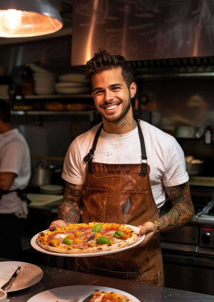 An attractive young chef tattoo plate pizza.