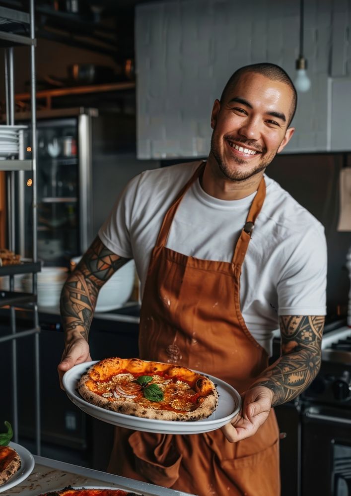 An attractive young chef tattoo pizza plate.