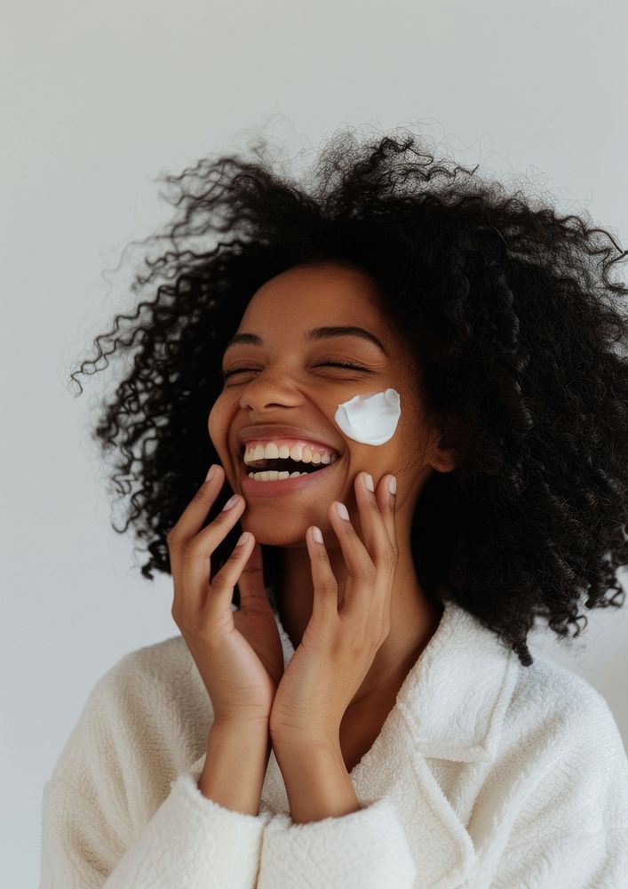 Woman applying cream on her face smile laughing person.