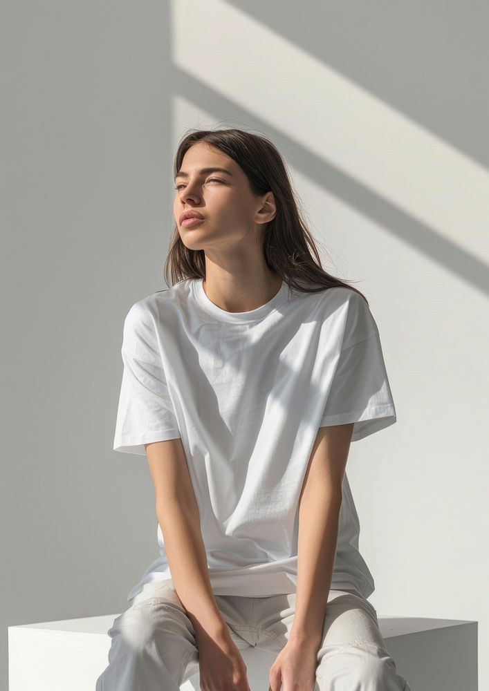 Woman wearing white t shirt mockup clothing apparel sitting.