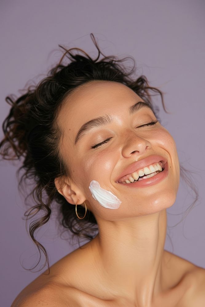 Woman side view laugh happily with lotion on cheeck smile laughing dimples.
