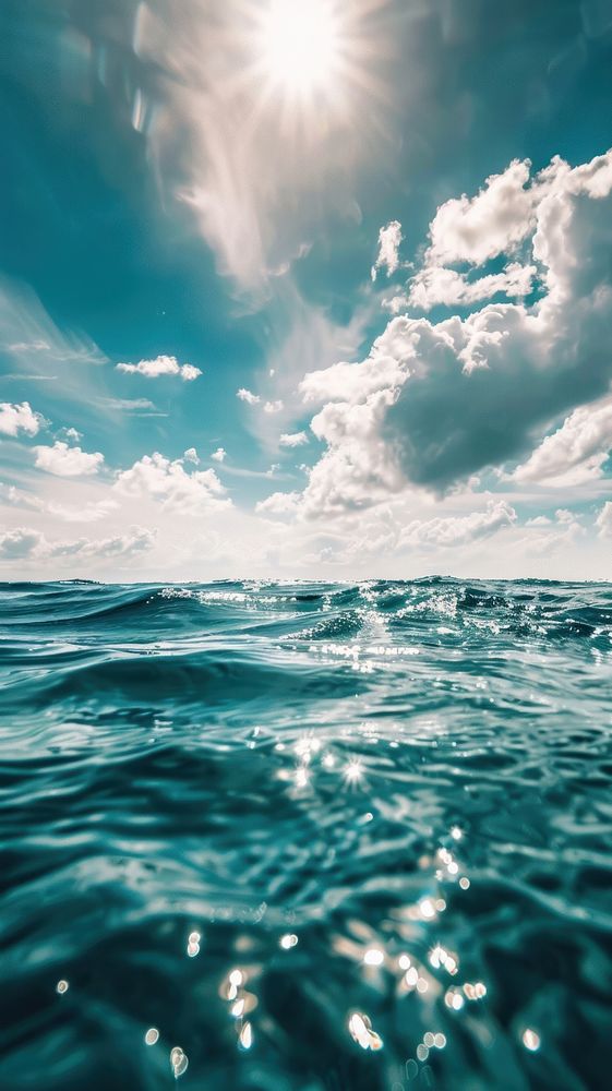 Blue sea ocean water surface and underwater with sunny and cloudy sky outdoors horizon scenery.